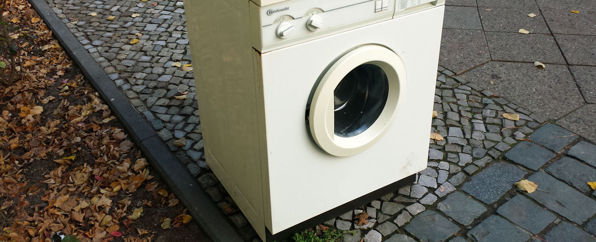 Foto: eine Waschmaschine steht auf der Straße und wartet auf Abholung